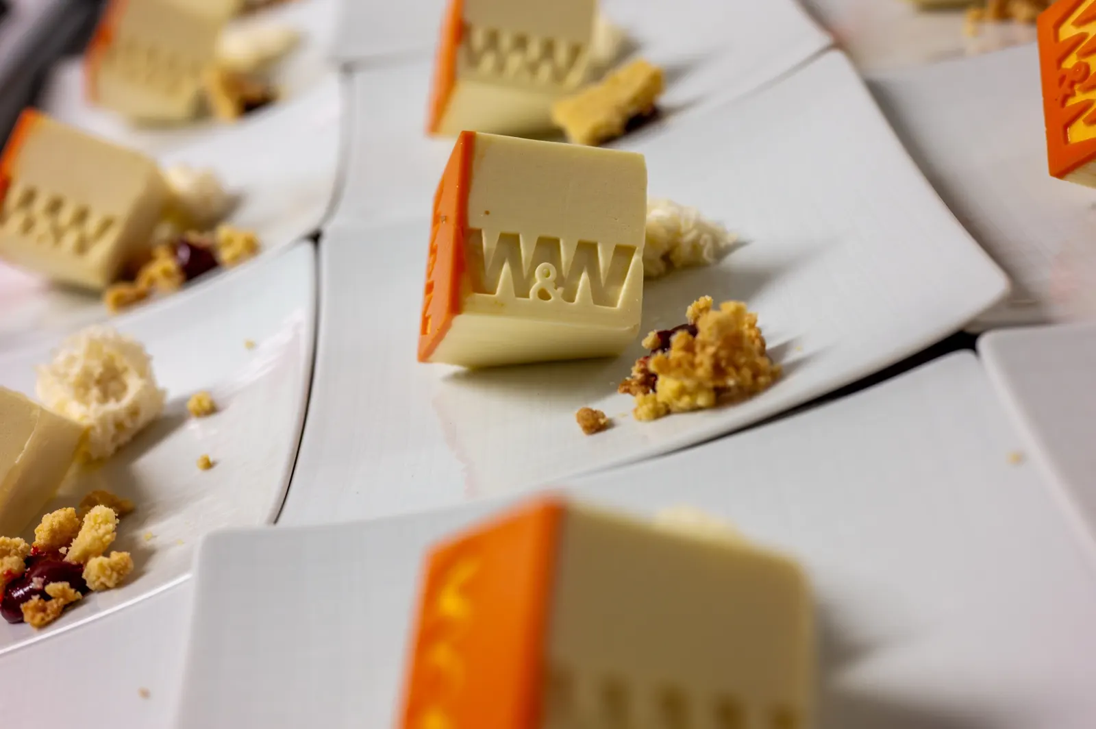 Nahaufnahme eines Desserts mit Schokoladen-Würfel auf weißem Teller