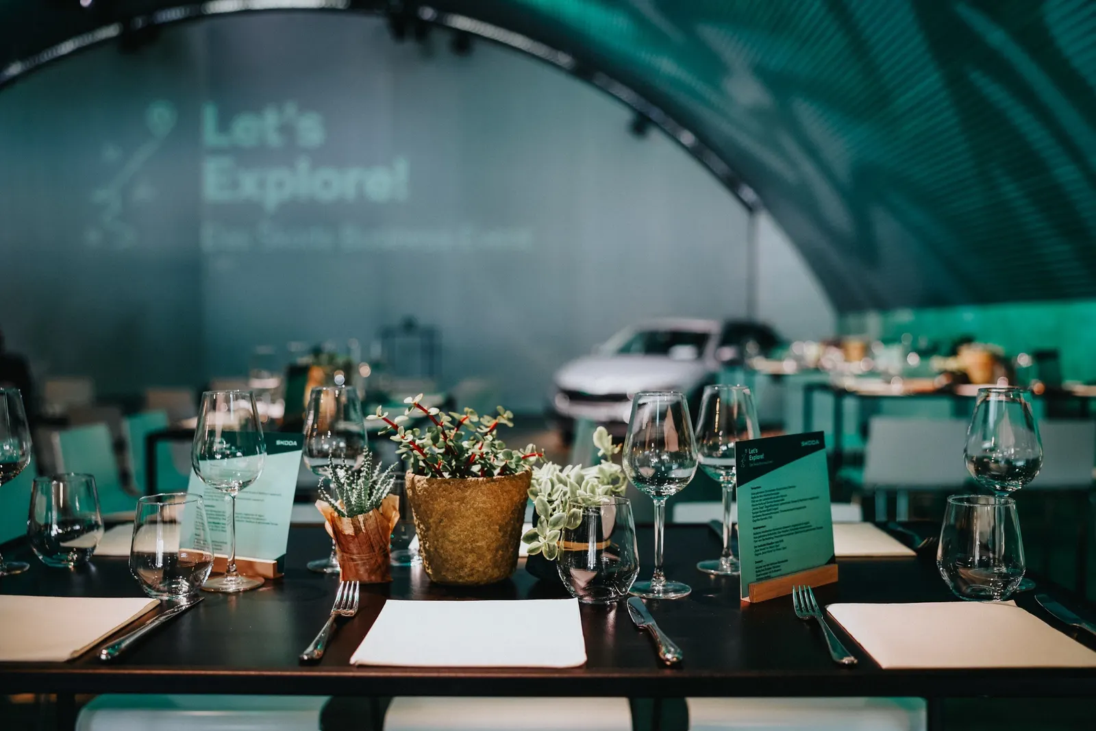 Eingedeckte Dinner-Tische im grün beleuchteten Hangar