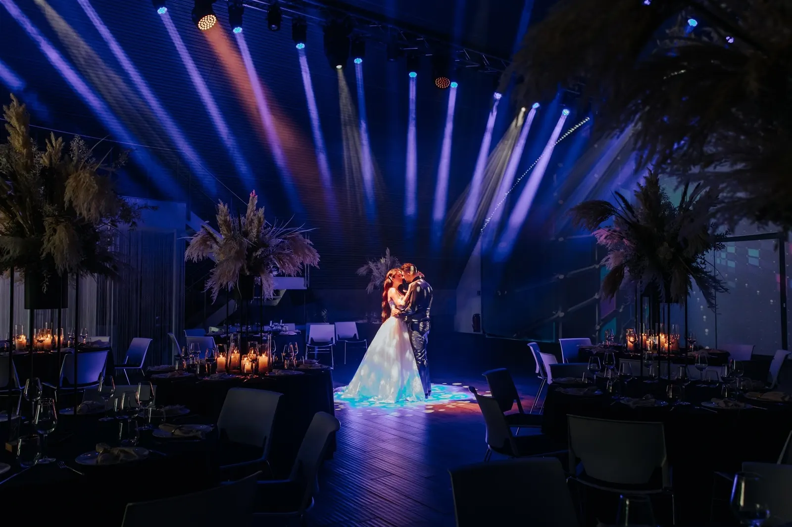 Hochzeitspaar beim Tanz unter blauen Lichtstrahlen