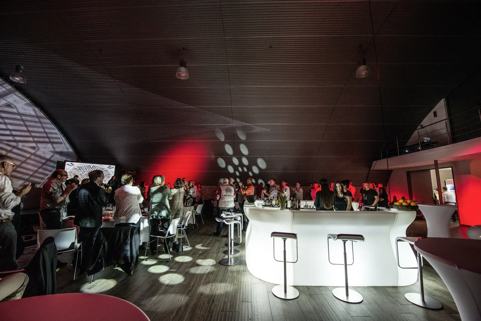 Volle Bar im Hangar mit Gästen und Lichtmustern