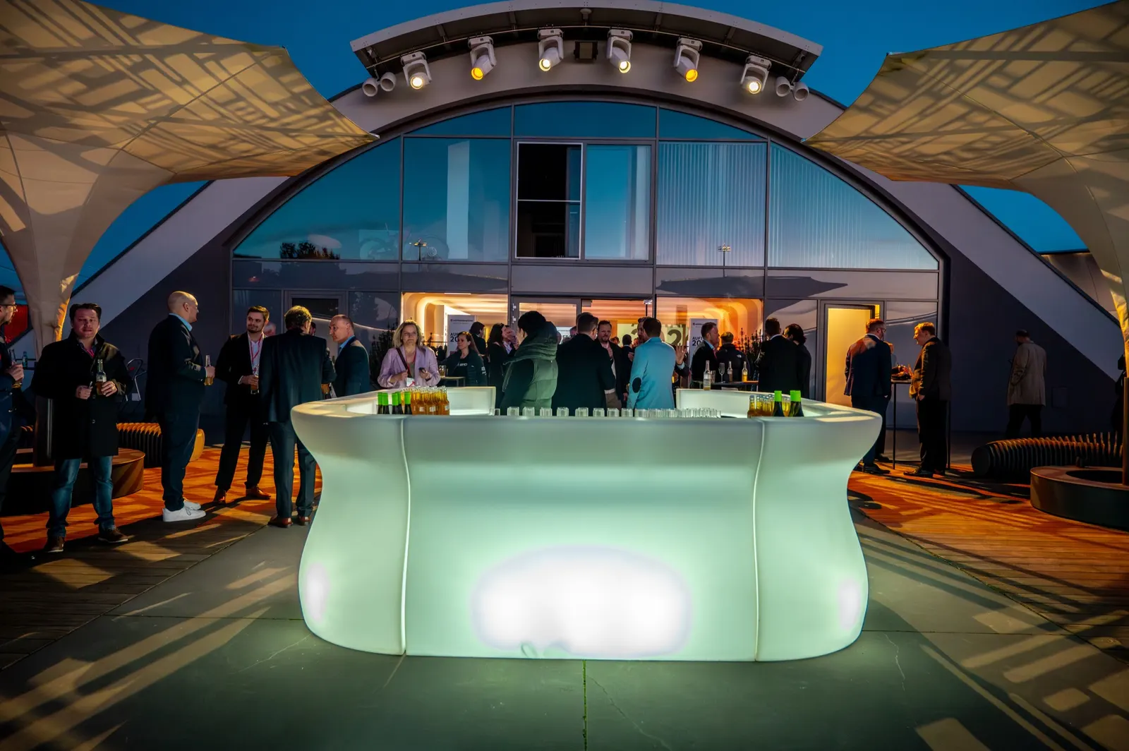 Leuchtende Bar vor dem Hangar auf der Terrasse in der Dämmerung