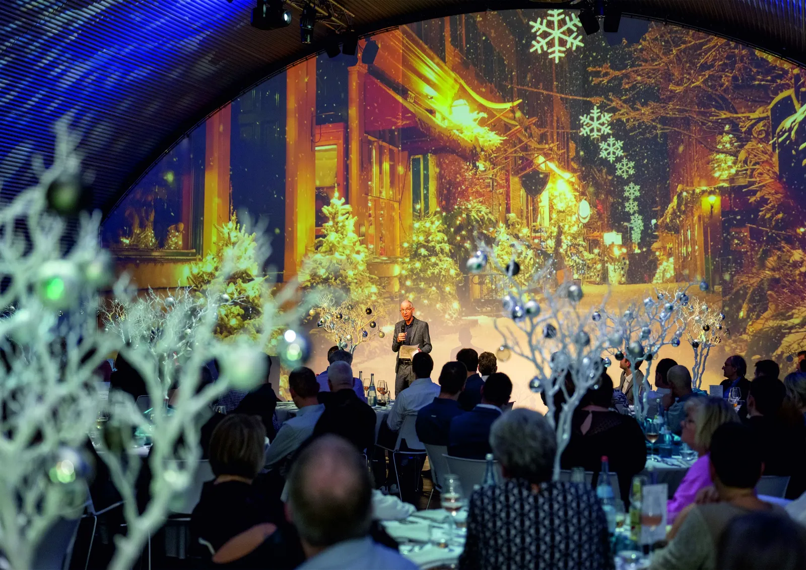 Festliches Dinner mit winterlicher Projektion und weißen Bäumen